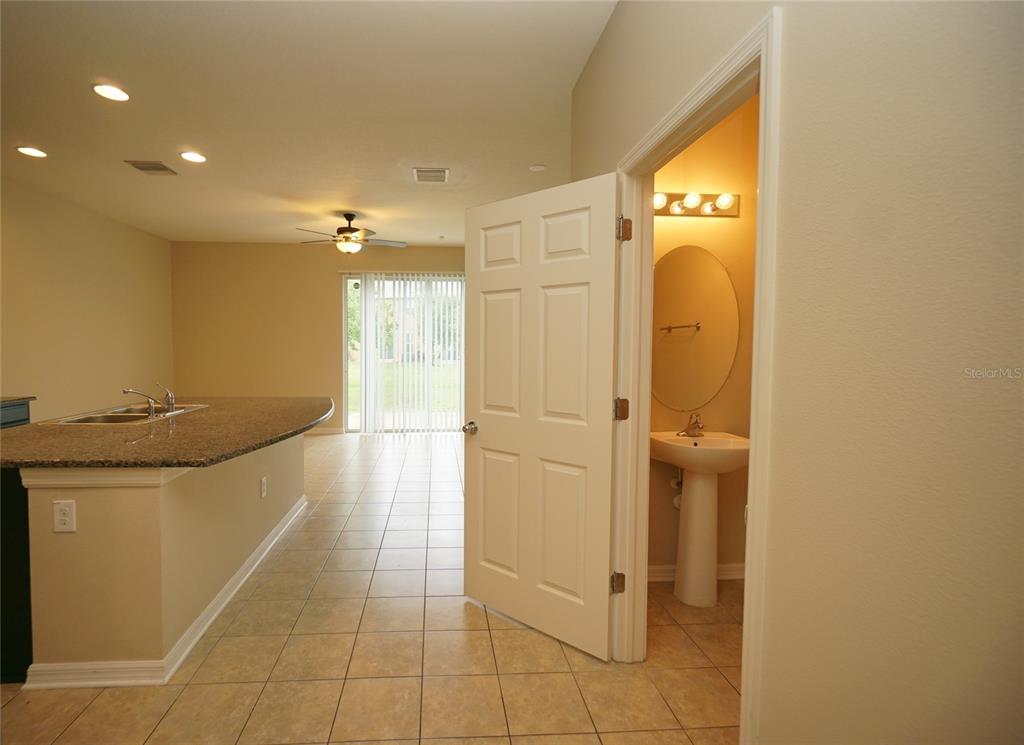 A kitchen with a granite breakfast bar opens to a living area and a bathroom — 6938 TOWNE LAKE ROAD, RIVERVIEW, FL