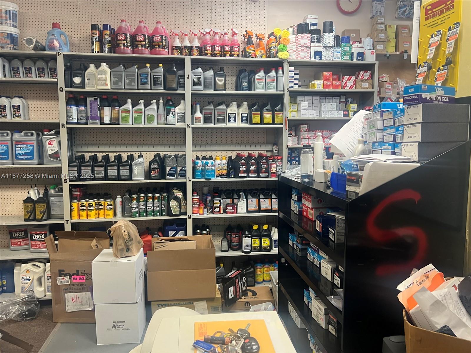 A cluttered auto parts store interior features shelves stocked with various automotive fluids and supplies — LAUDERDALE LAKES, FL
