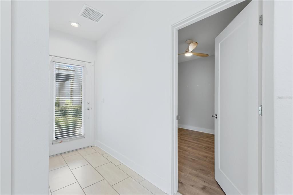 A tiled entryway leads to a doorway opening into a room with wood-look flooring — 2551 11TH PL N, ST PETERSBURG, FL