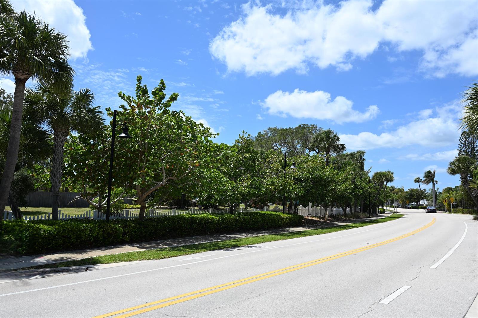 A paved road curves past a row of green trees and a white picket fence — 18019 N Highway A1a, Jupiter FL 33477, JUPITER, FL