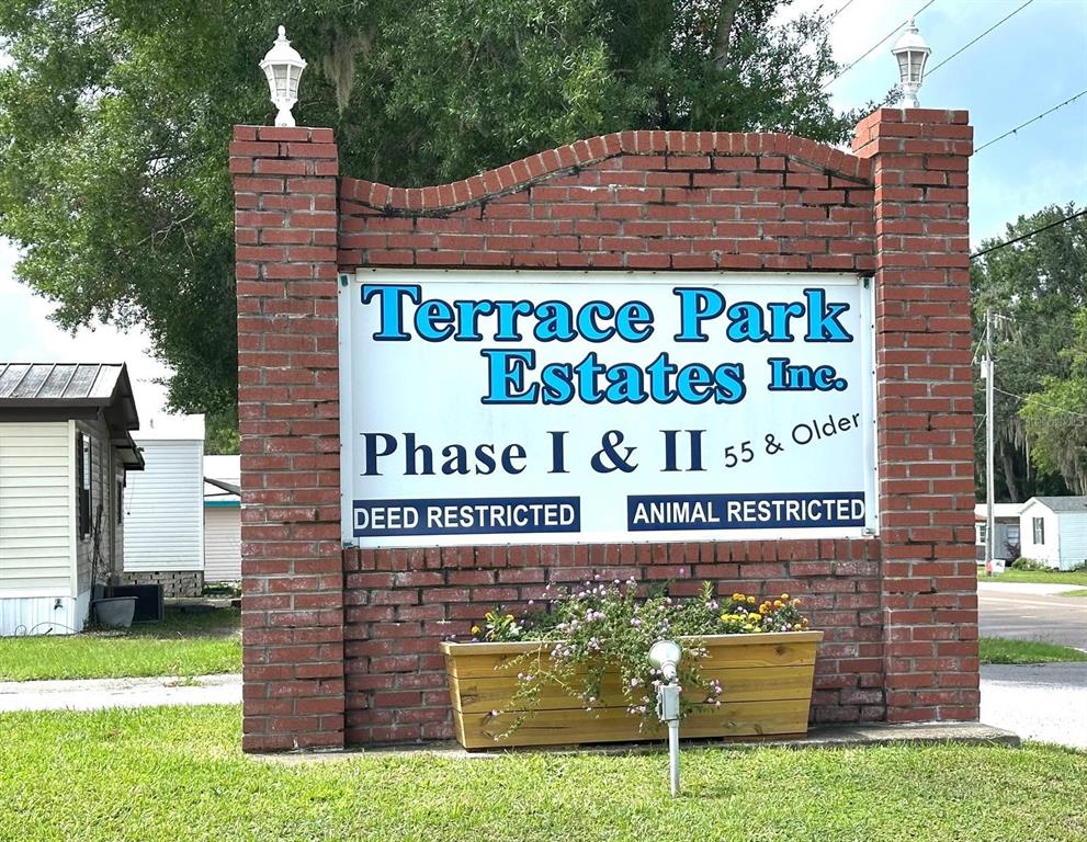 A brick sign for Terrace Park Estates stands in front of a mobile home community — 3937 CHRIS DRIVE, WESLEY CHAPEL, FL
