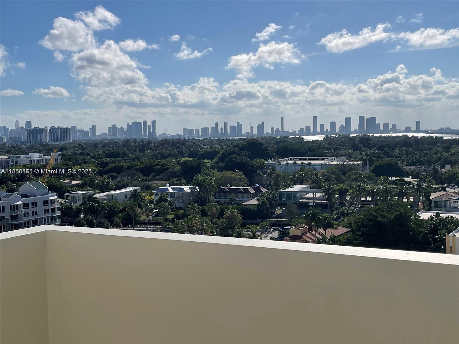 A high-angle view shows a residential neighborhood with a distant city skyline under clouds — 2899 Collins Ave # 1420, Miami Beach FL 33140, MIAMI BEACH, FL