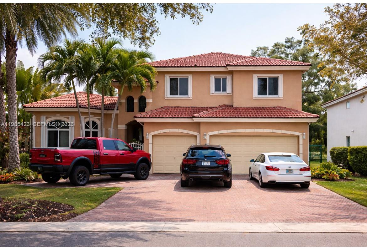 A two-story tan stucco house with a red tile roof and a three-car garage — 1958 SE 23rd Ct, Homestead FL 33035, HOMESTEAD, FL