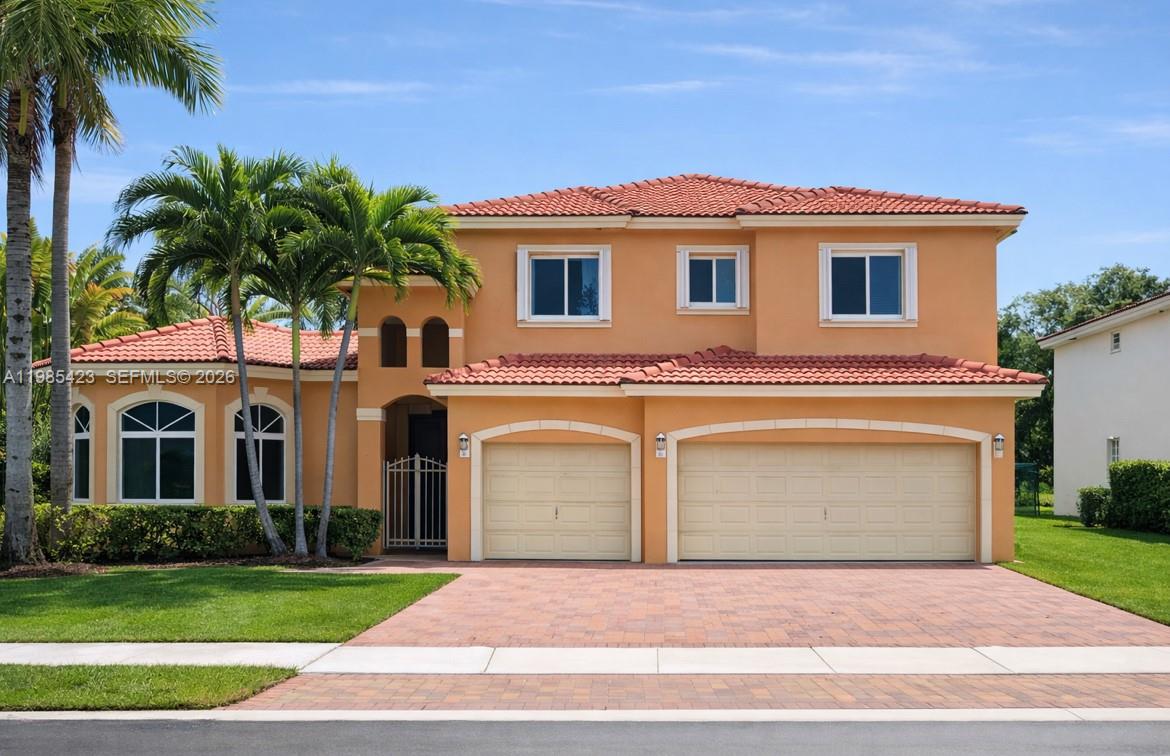 A two-story orange stucco house features a three-car garage and a red tile roof — 1958 SE 23rd Ct, Homestead FL 33035, HOMESTEAD, FL
