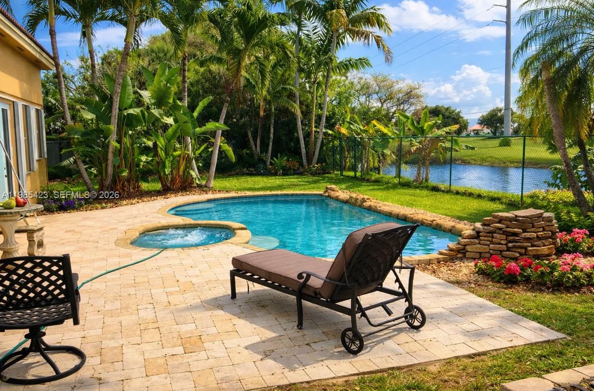 A backyard patio features a swimming pool, a hot tub, and a lounge chair — 1958 SE 23rd Ct, Homestead FL 33035, HOMESTEAD, FL