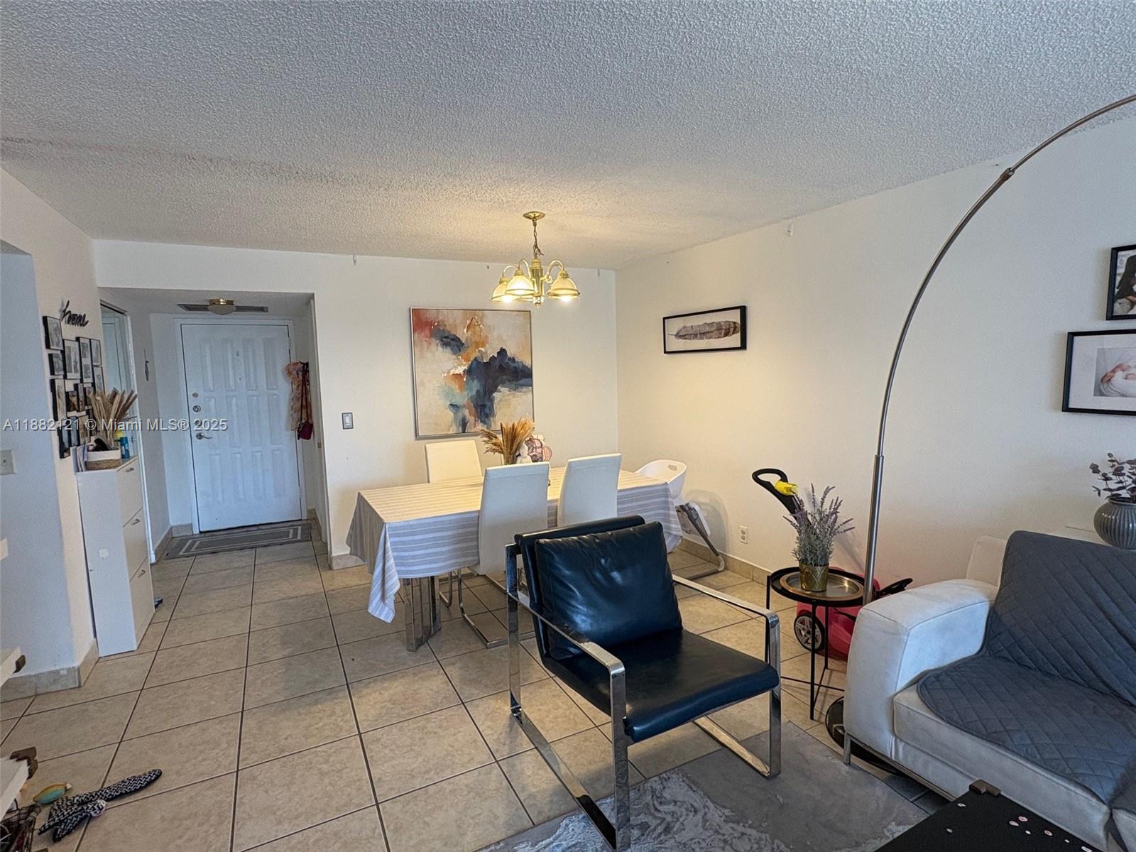 A dining area and living space feature tile flooring, a chandelier, and modern furniture — 200 Leslie Dr # 228, Hallandale Beach FL 33009, HALLANDALE BEACH, FL