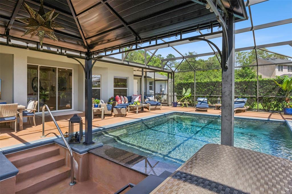 A screened-in patio features a swimming pool, outdoor seating, and a covered dining area — 7648 LAKE ANGELINA DRIVE, MOUNT DORA, FL
