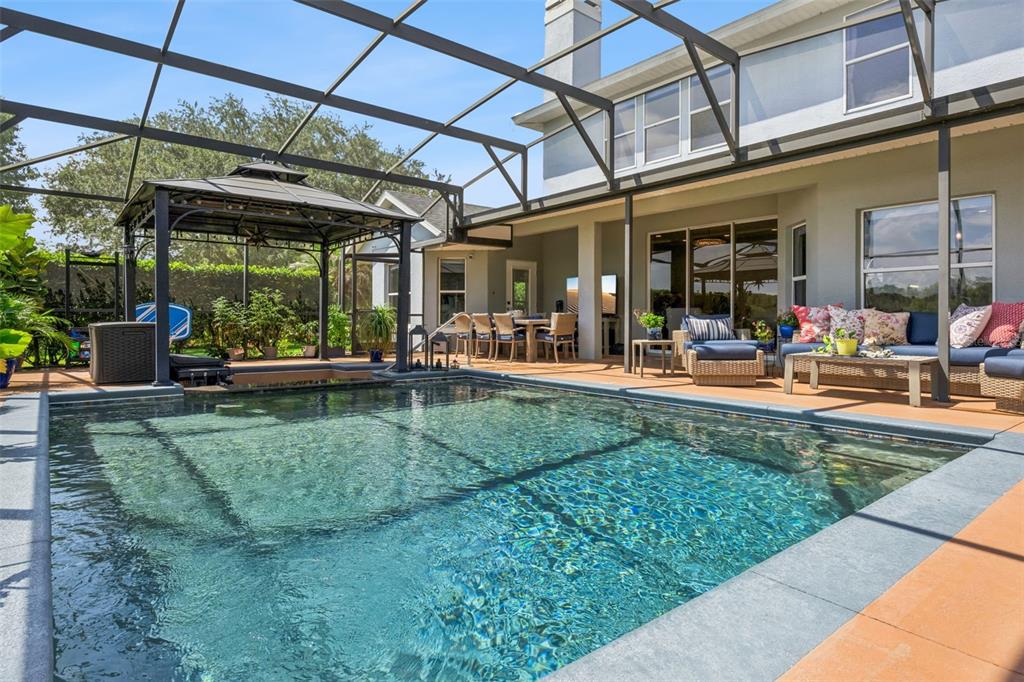 A swimming pool with a screened enclosure, gazebo, and patio furniture in a backyard — 7648 LAKE ANGELINA DRIVE, MOUNT DORA, FL