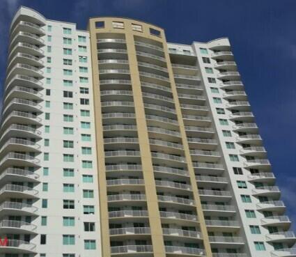 A low-angle view of a tall, modern residential high-rise building with curved balconies — 1755 E Hallandale Beach Boulevard # 2104e, FL 33009, FL