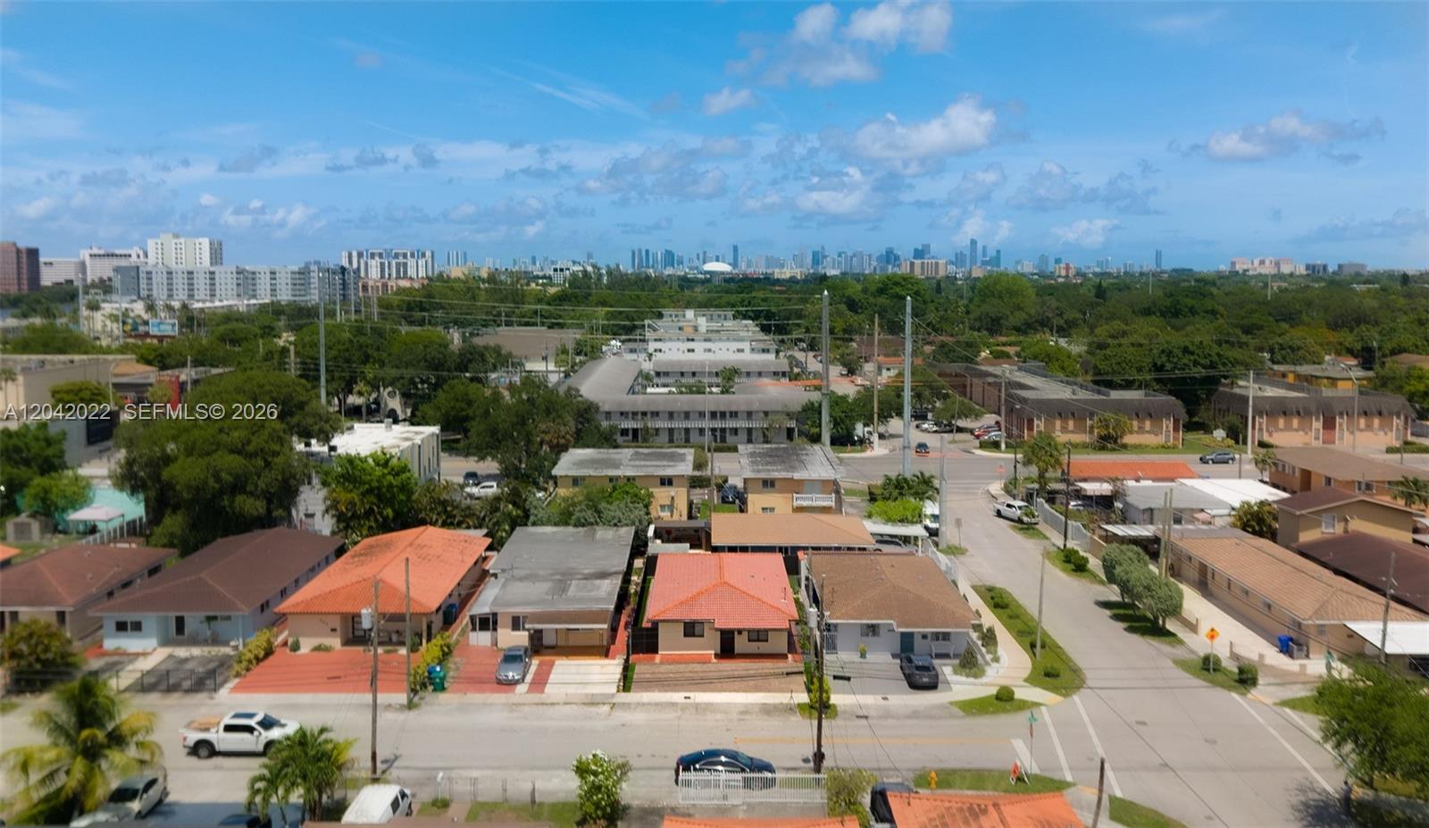 An aerial view shows a residential neighborhood with single-family homes and a distant city skyline — 509 NW 57th Ct, Miami FL 33126, MIAMI, FL