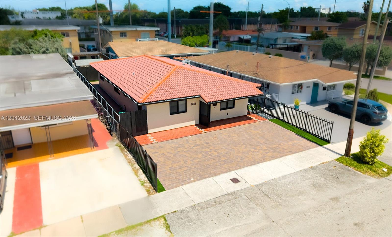 An aerial view shows a single-story house with a red tile roof and paved driveway — 509 NW 57th Ct, Miami FL 33126, MIAMI, FL