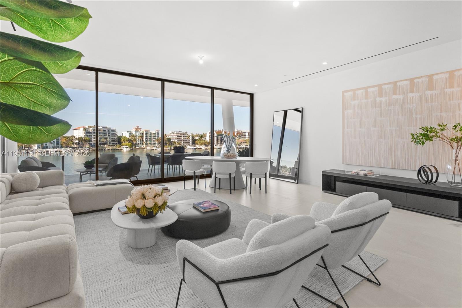 A modern living room features floor-to-ceiling windows overlooking a waterfront view and outdoor terrace — 5 Grove Isle # S301, Coconut Grove FL 33133, COCONUT GROVE, FL