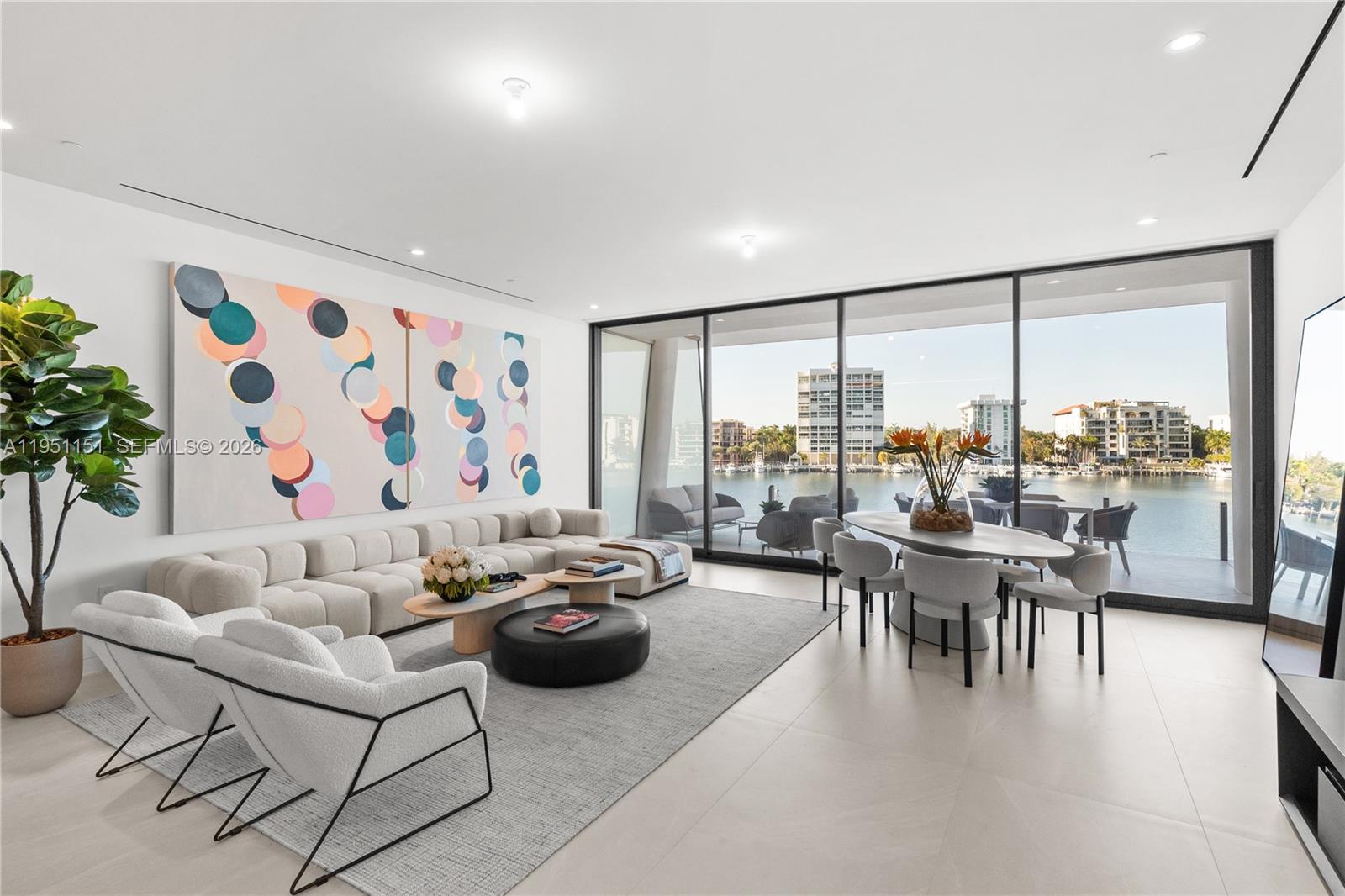 A modern living and dining room features floor-to-ceiling windows overlooking a waterfront marina — 5 Grove Isle # S301, Coconut Grove FL 33133, COCONUT GROVE, FL