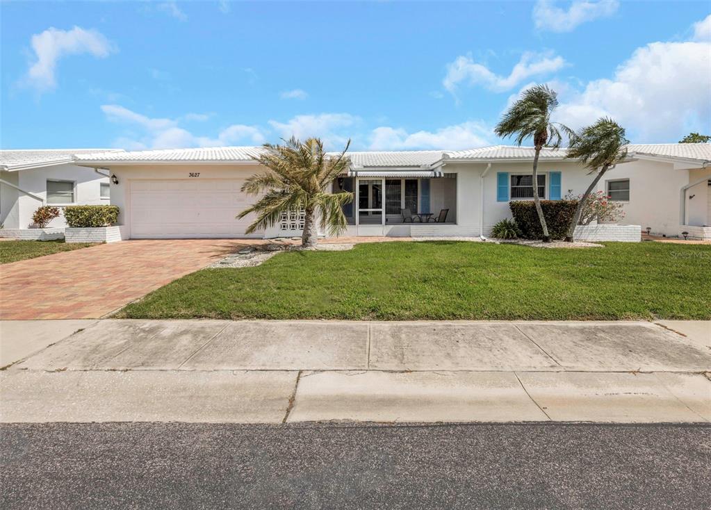 A single-story white house with a two-car garage, a palm tree, and a front lawn — 3627 100TH PLACE N UNIT 4, PINELLAS PARK, FL
