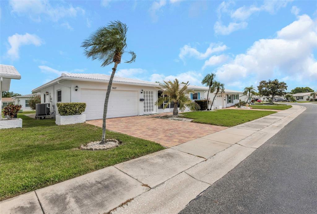 A single-story white house with a paved driveway and palm trees under a blue sky — 3627 100TH PLACE N UNIT 4, PINELLAS PARK, FL
