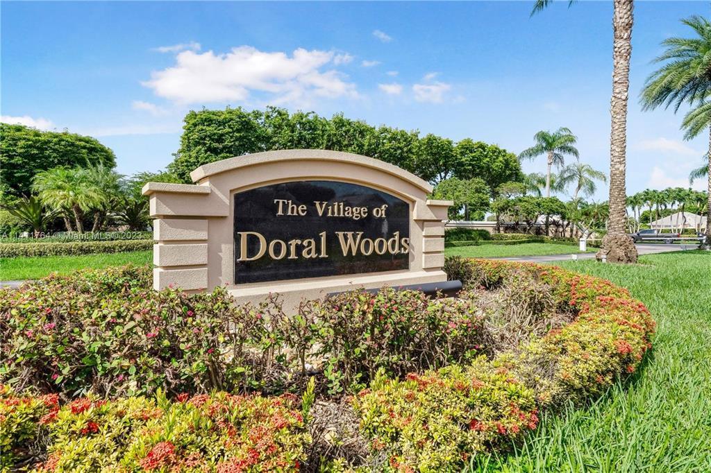 A stone monument sign for The Village of Doral Woods sits in a landscaped garden — 4825 NW 98th Place, Doral FL 33178, DORAL, FL