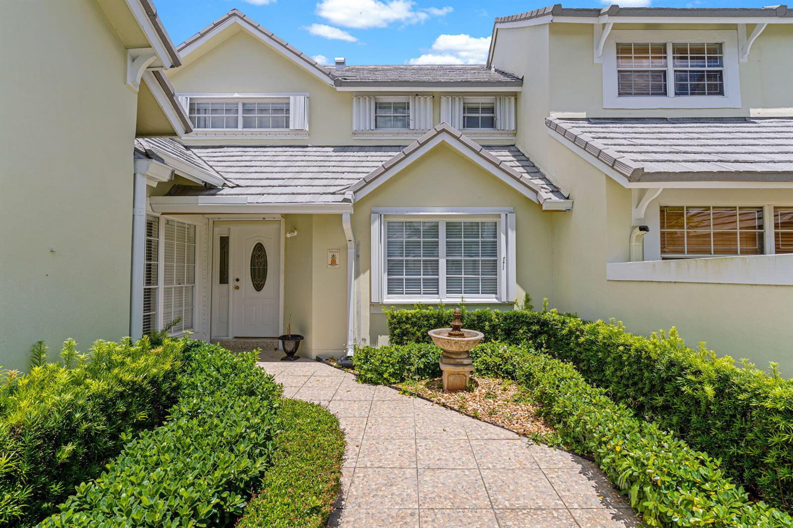 A paved walkway leads to the front entrance of a two-story house with light-colored siding — 4825 NW 98th Place, Doral FL 33178, DORAL, FL