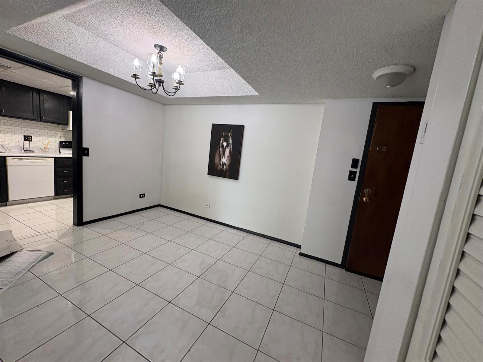 A dining area with white tile floors, a chandelier, and a horse portrait on the wall — 3660 Inverrary Drive # 1b, Lauderhill FL 33319, LAUDERHILL, FL