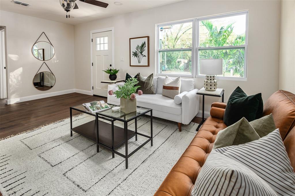 A living room features a leather sofa, a white loveseat, and a glass coffee table — 1008 E NORFOLK STREET, TAMPA, FL
