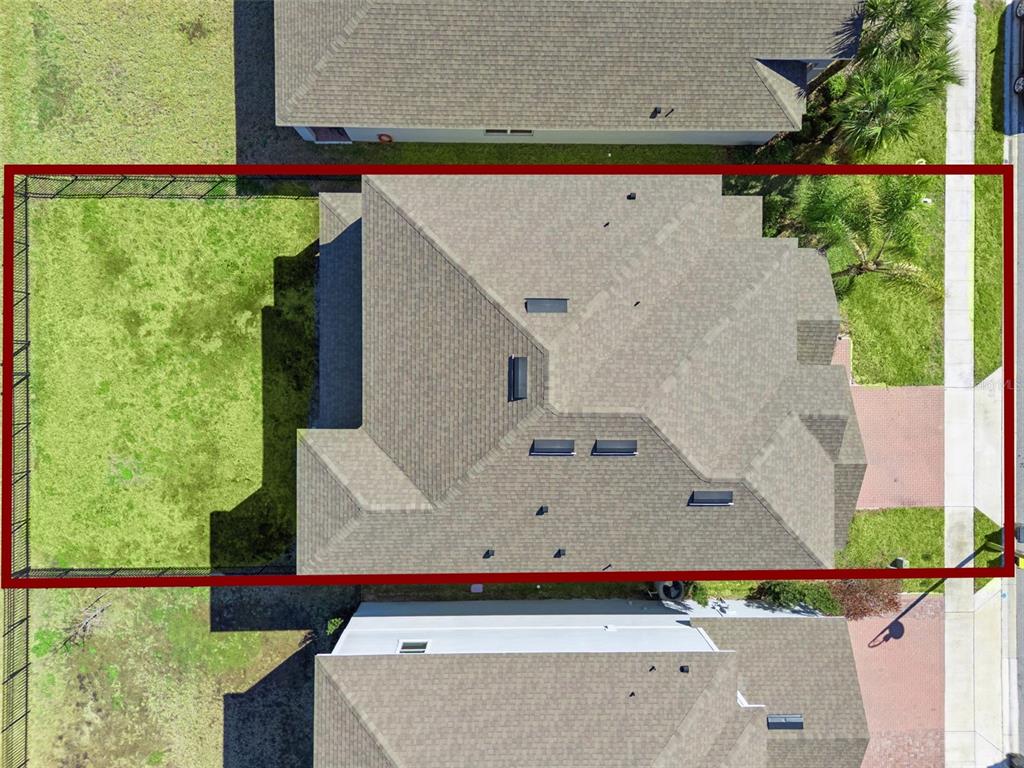 An aerial view shows a house with a fenced backyard and a shingled roof — 609 FORTUNA DRIVE, DAVENPORT, FL