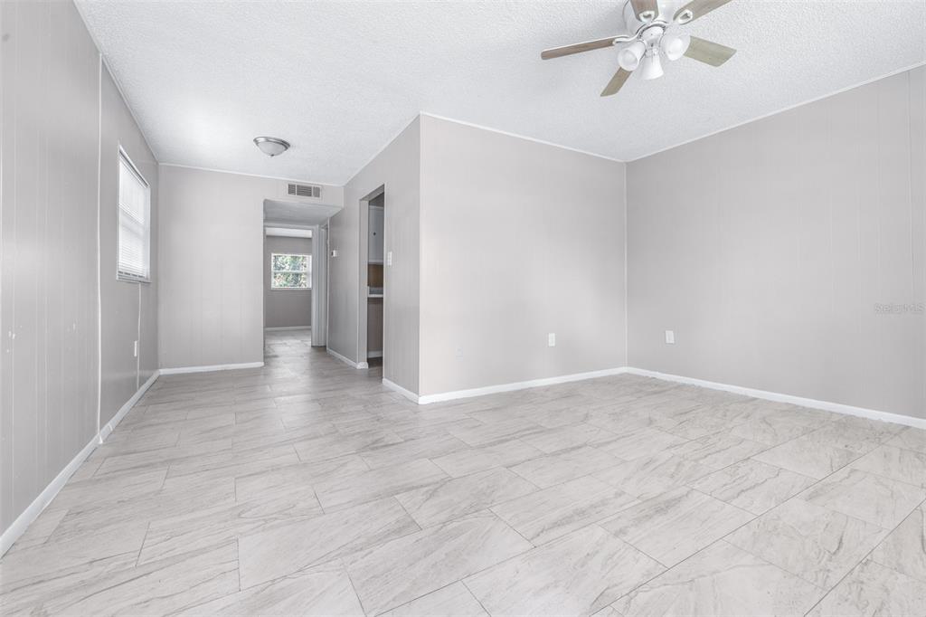 A living room with light gray walls, white trim, and light-colored tile flooring — 5901 GIBSON AVENUE, TAMPA, FL