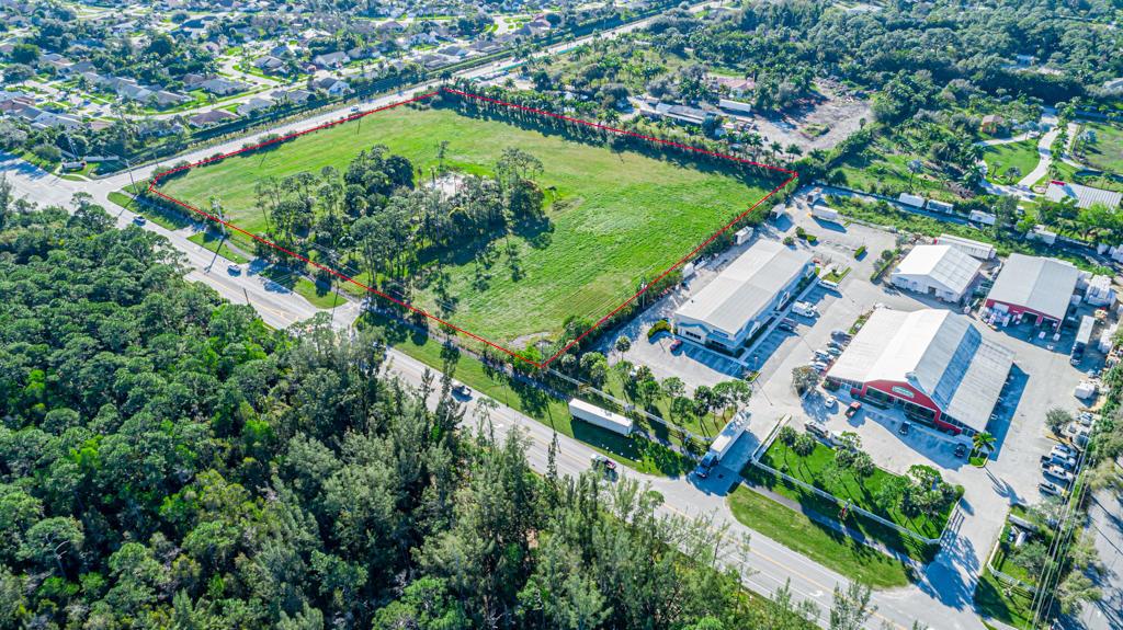An aerial view shows a large, rectangular vacant lot outlined in red next to commercial buildings — 12900 Okeechobee Boulevard, FL 33470, FL