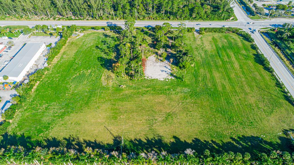 An aerial view shows a large, grassy vacant lot with a central cluster of trees — 12900 Okeechobee Boulevard, FL 33470, FL