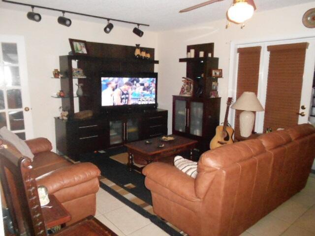 A living room features brown leather sofas, a dark wood entertainment center, and track lighting — 54 Matador Lane, Davie FL 33324, DAVIE, FL