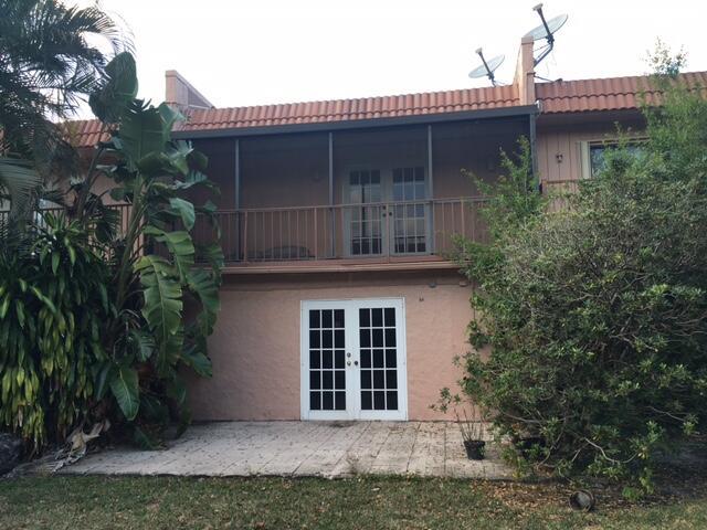 A two-story building features a ground-level patio with French doors and an upper screened balcony — 54 Matador Lane, Davie FL 33324, DAVIE, FL