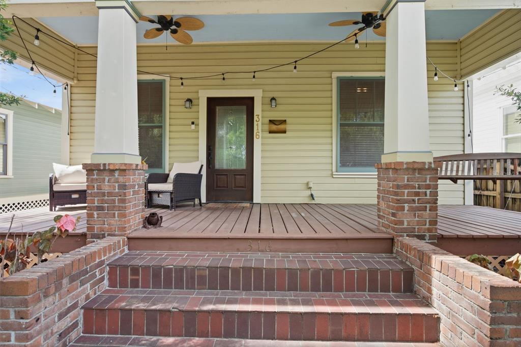 A front porch with brick steps, columns, and string lights leads to a wooden front door — 316 E FRANCES AVENUE, TAMPA, FL