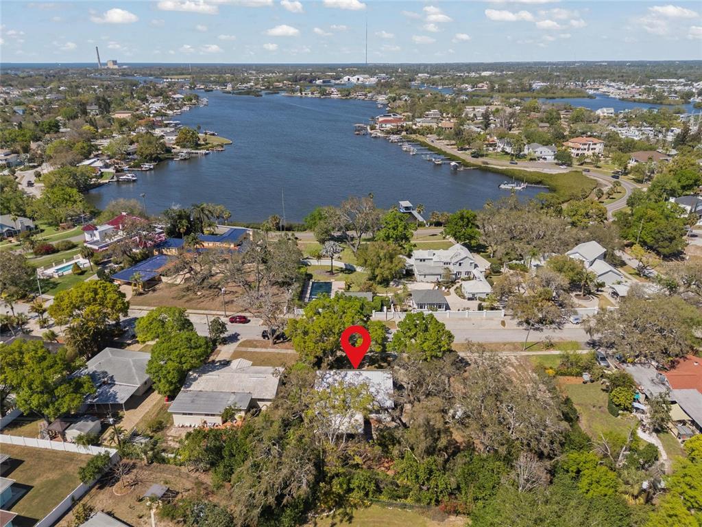 An aerial view shows a residential property with a red location pin near water — 502 HILLCREST AVENUE, TARPON SPRINGS, FL