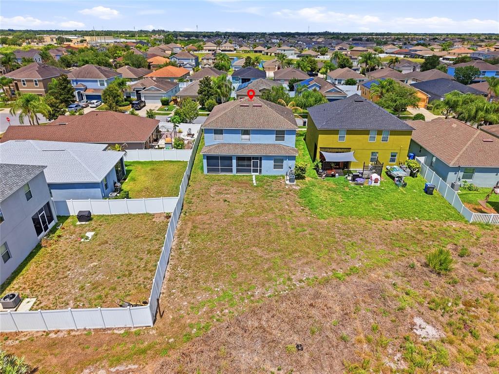 An aerial view shows a two-story blue house with a gray roof and driveway — 909 MEADOW GLADE DRIVE, RUSKIN, FL