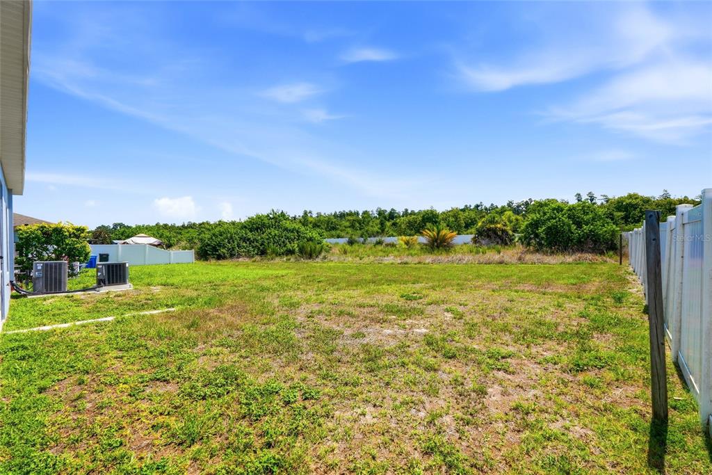 An aerial view shows a blue two-story house with a screened patio and backyard — 909 MEADOW GLADE DRIVE, RUSKIN, FL