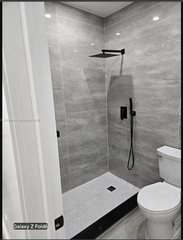 A bathroom features a walk-in shower with gray tiled walls and a black rainfall showerhead — 13240 NE 4 Ave # 1, North Miami FL 33161, NORTH MIAMI, FL