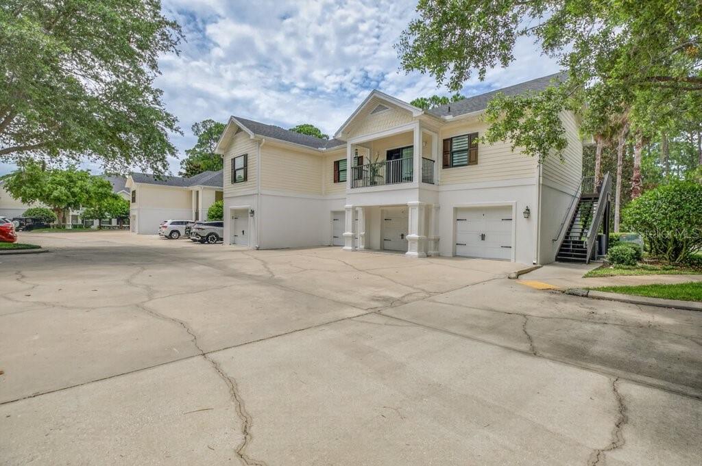 A two-story yellow building with multiple garage doors and an exterior staircase — 112 LAUREL WOOD WAY UNIT 205, ST AUGUSTINE, FL