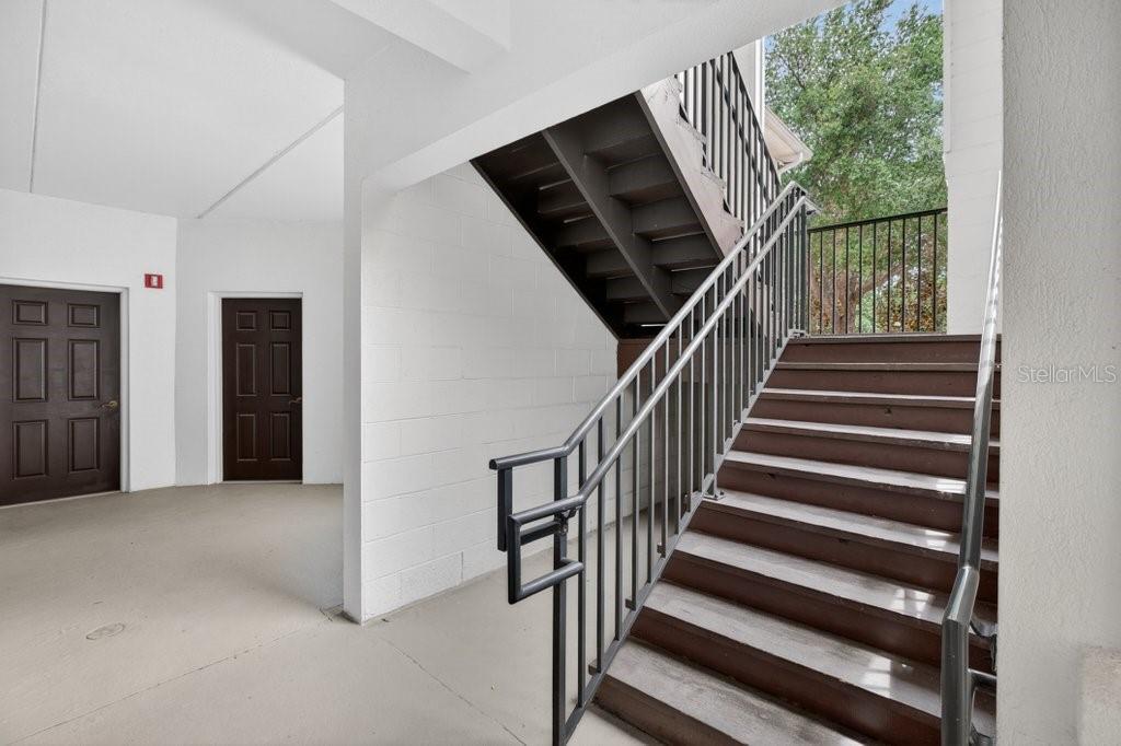 An outdoor staircase with metal railings leads to an upper level next to two doors — 112 LAUREL WOOD WAY UNIT 205, ST AUGUSTINE, FL
