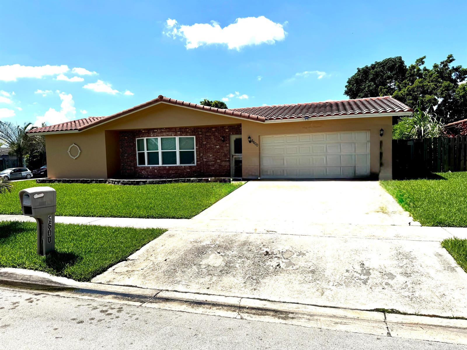 A single-story house with a brick facade, tile roof, and a concrete driveway — 6600 NW 23rd Street, Margate FL 33063, MARGATE, FL