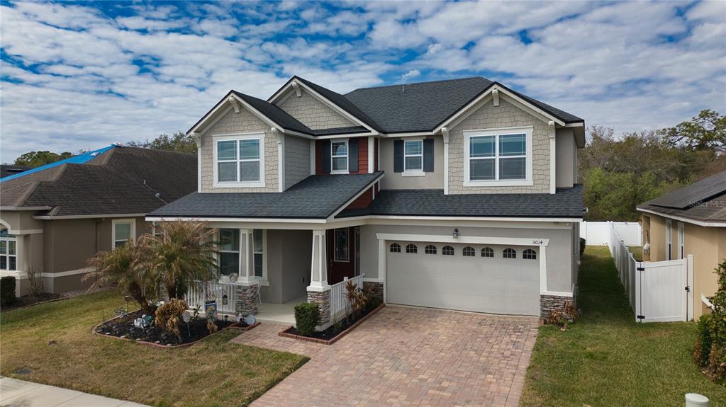 A two-story suburban house with a paved driveway, a front porch, and a two-car garage — 3014 SERA BELLA WAY, KISSIMMEE, FL