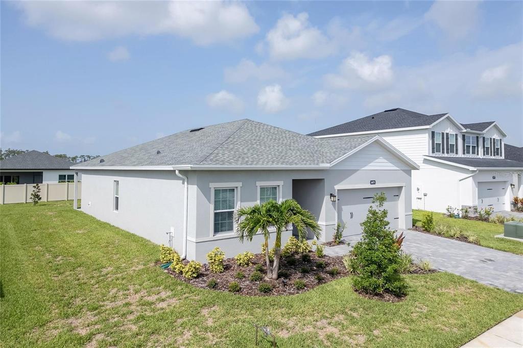 A single-story gray house with a two-car garage and a landscaped front yard — 16873 CASTORO DRIVE, PORT CHARLOTTE, FL