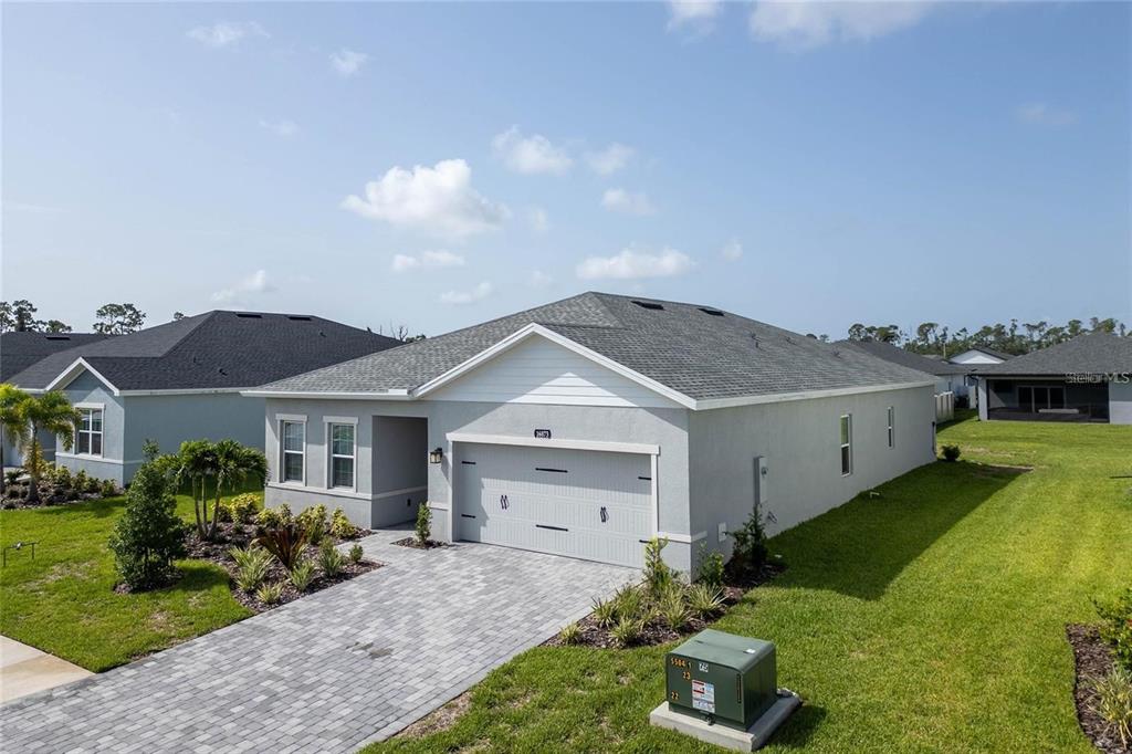 A single-story gray house with a two-car garage and a paved driveway — 16873 CASTORO DRIVE, PORT CHARLOTTE, FL