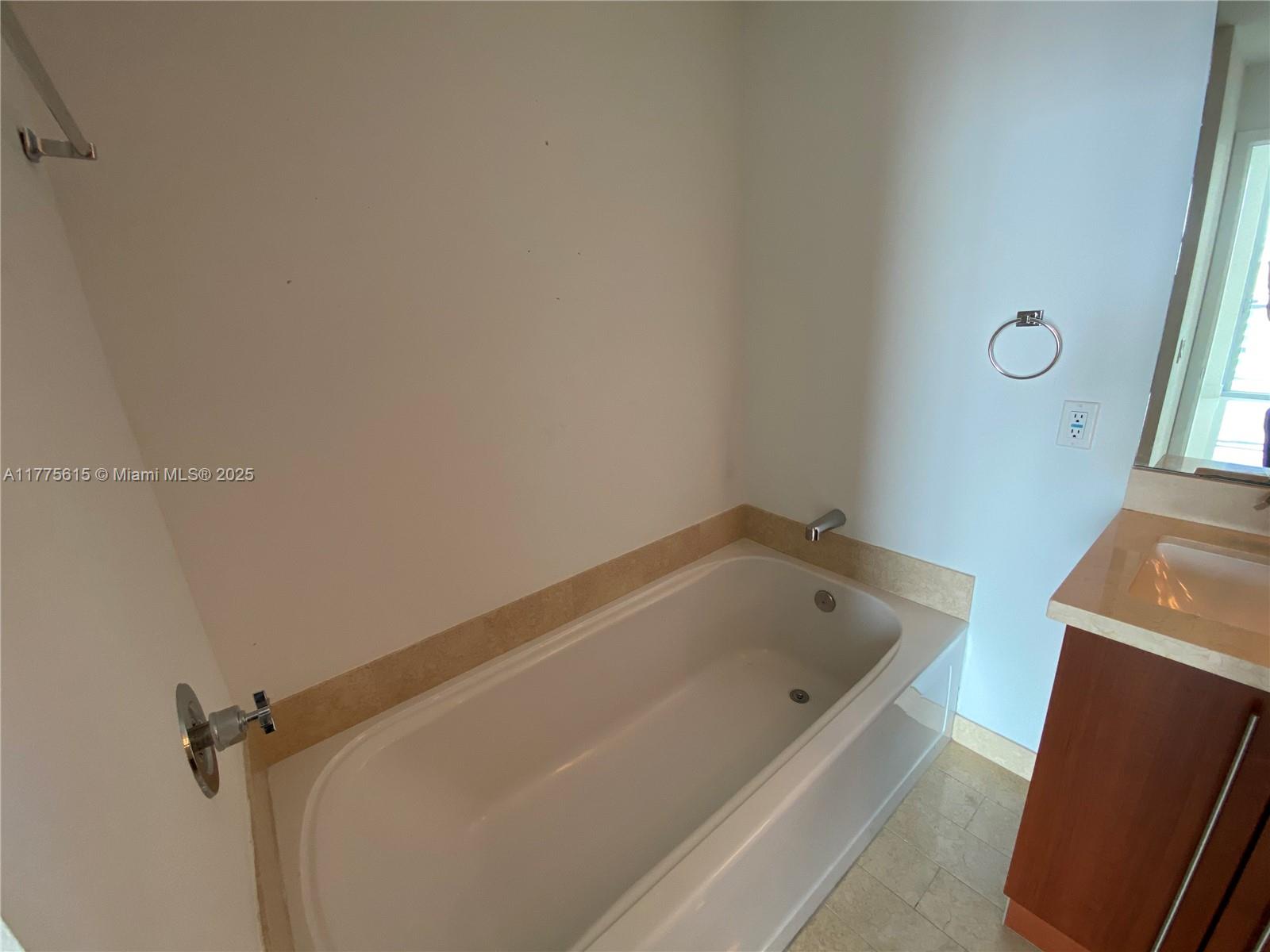 A bathroom features a white bathtub, a vanity with a countertop, and wall-mounted fixtures — 79 SW 12 ST, Miami FL 33130, MIAMI, FL
