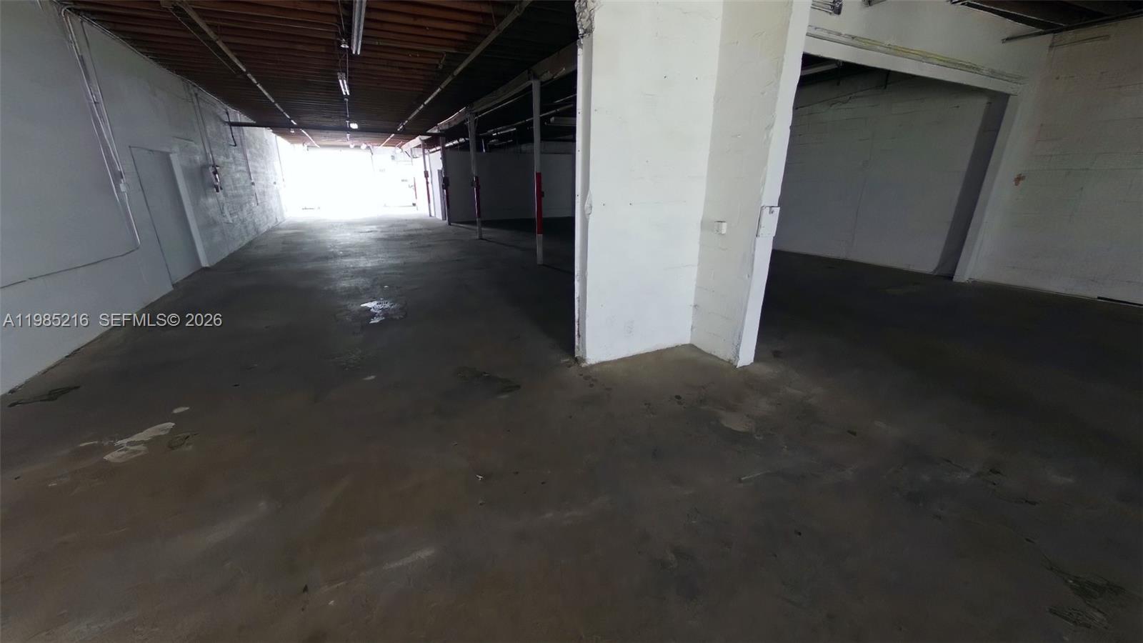 An empty industrial warehouse space features concrete floors, white walls, and exposed ceiling beams — 1079 E 24th St # 1079, Hialeah FL 33013, HIALEAH, FL