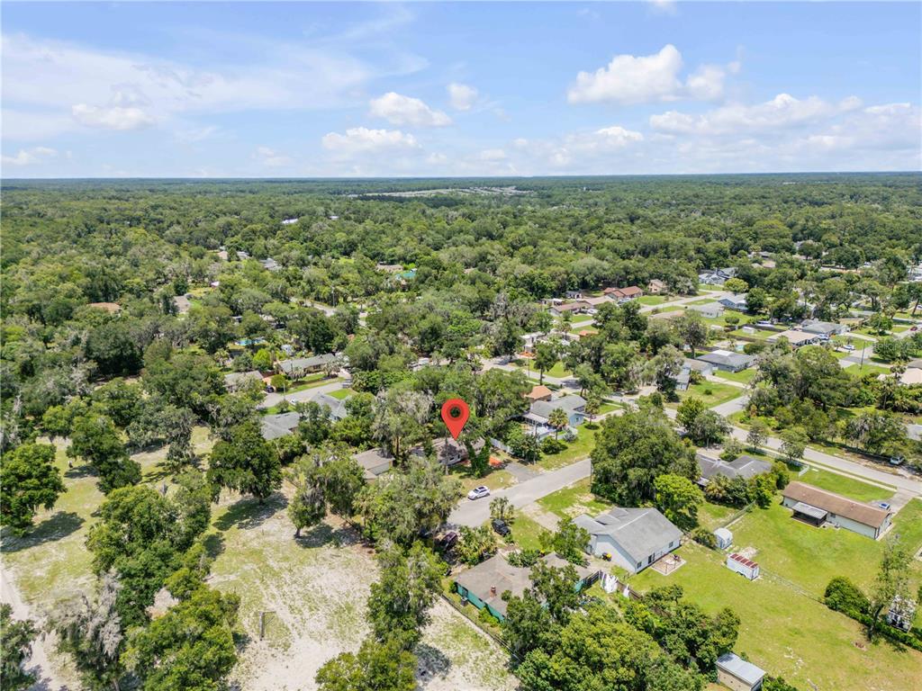 An aerial view shows a residential neighborhood with a red location pin marking a house — 380 JULIA AVENUE, ORANGE CITY, FL