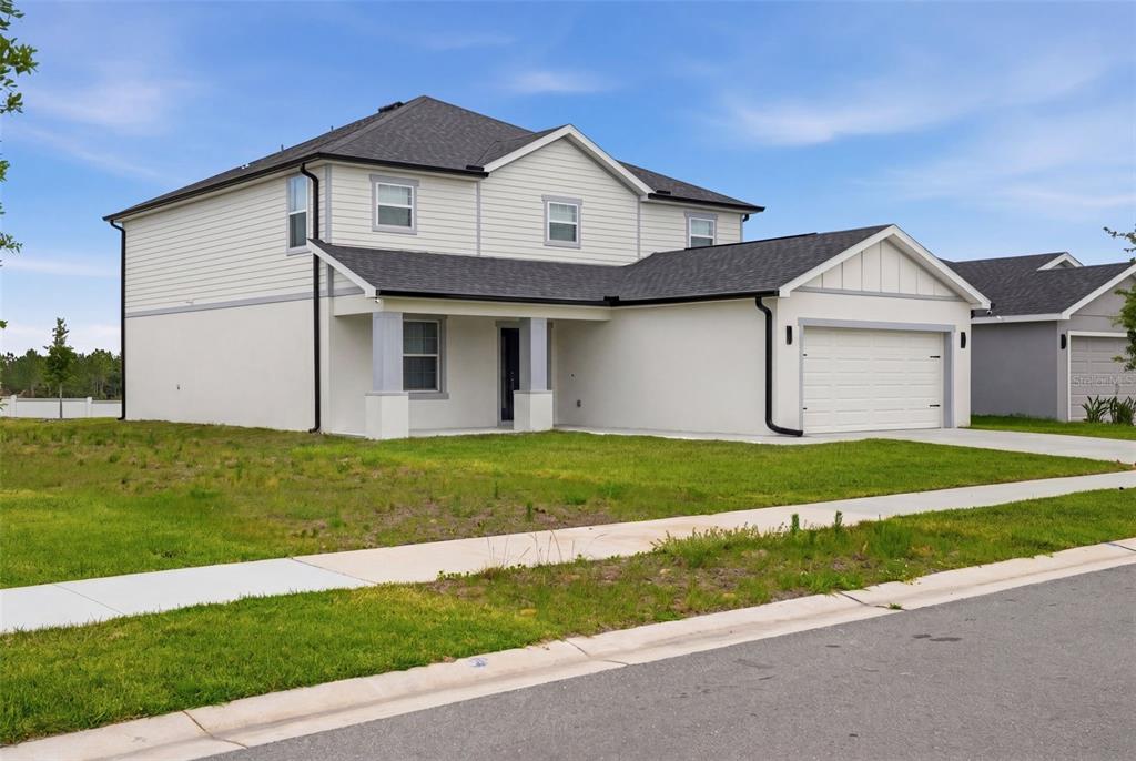 A two-story house with white stucco and siding, a shingled roof, and an attached garage — 1862 DAYSTAR DRIVE, HAINES CITY, FL