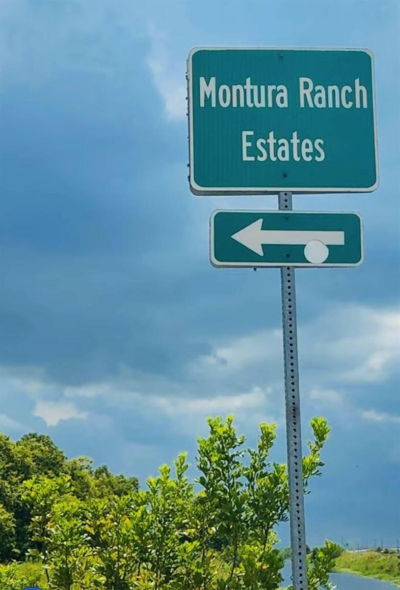 A green road sign points left toward Montura Ranch Estates against a cloudy blue sky — 756 Siboney Ave Street, Clewiston FL 33440, CLEWISTON, FL
