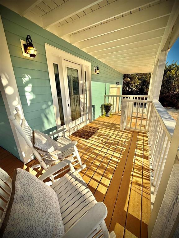 A wooden porch features two white rocking chairs and light blue siding under a roof — 6525 ENGRAM ROAD, NEW SMYRNA BEACH, FL