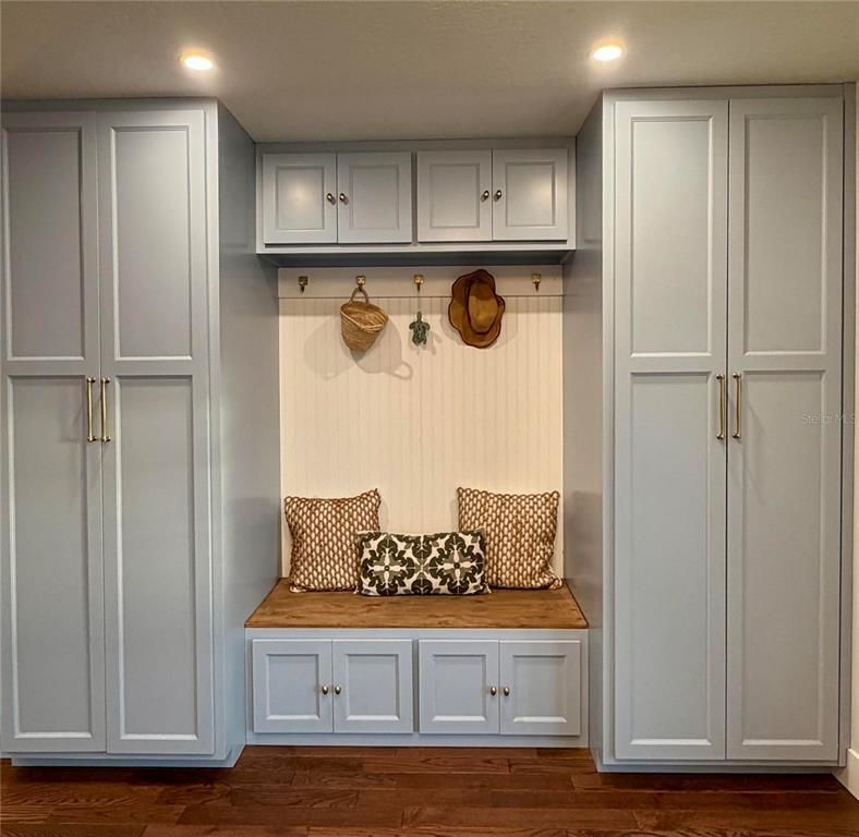 A mudroom features built-in light blue cabinets, a wooden bench, and beadboard wall paneling — 6525 ENGRAM ROAD, NEW SMYRNA BEACH, FL