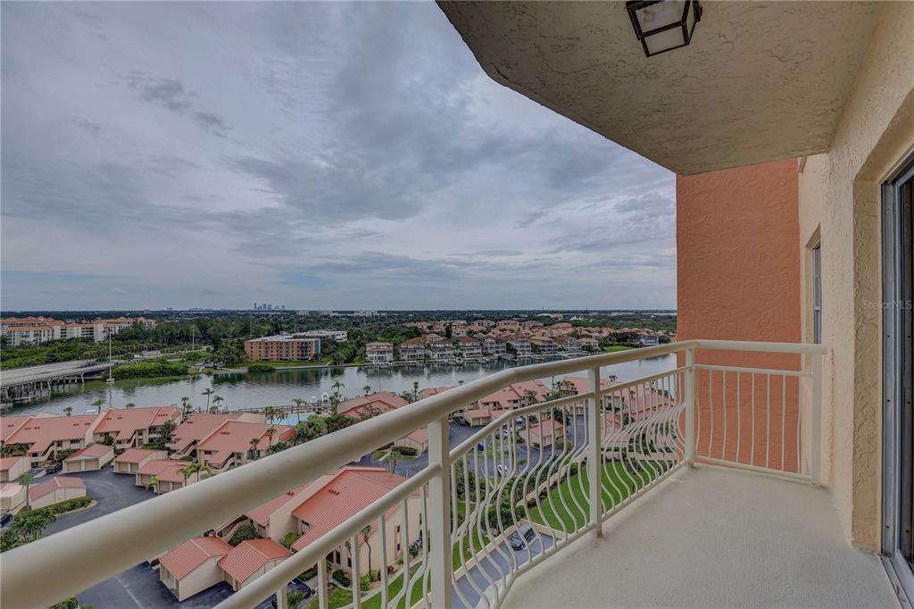 A high-angle view from a balcony overlooking a waterway, residential buildings, and a cloudy sky — 4900 BRITTANY DRIVE S UNIT 1409, ST PETERSBURG, FL