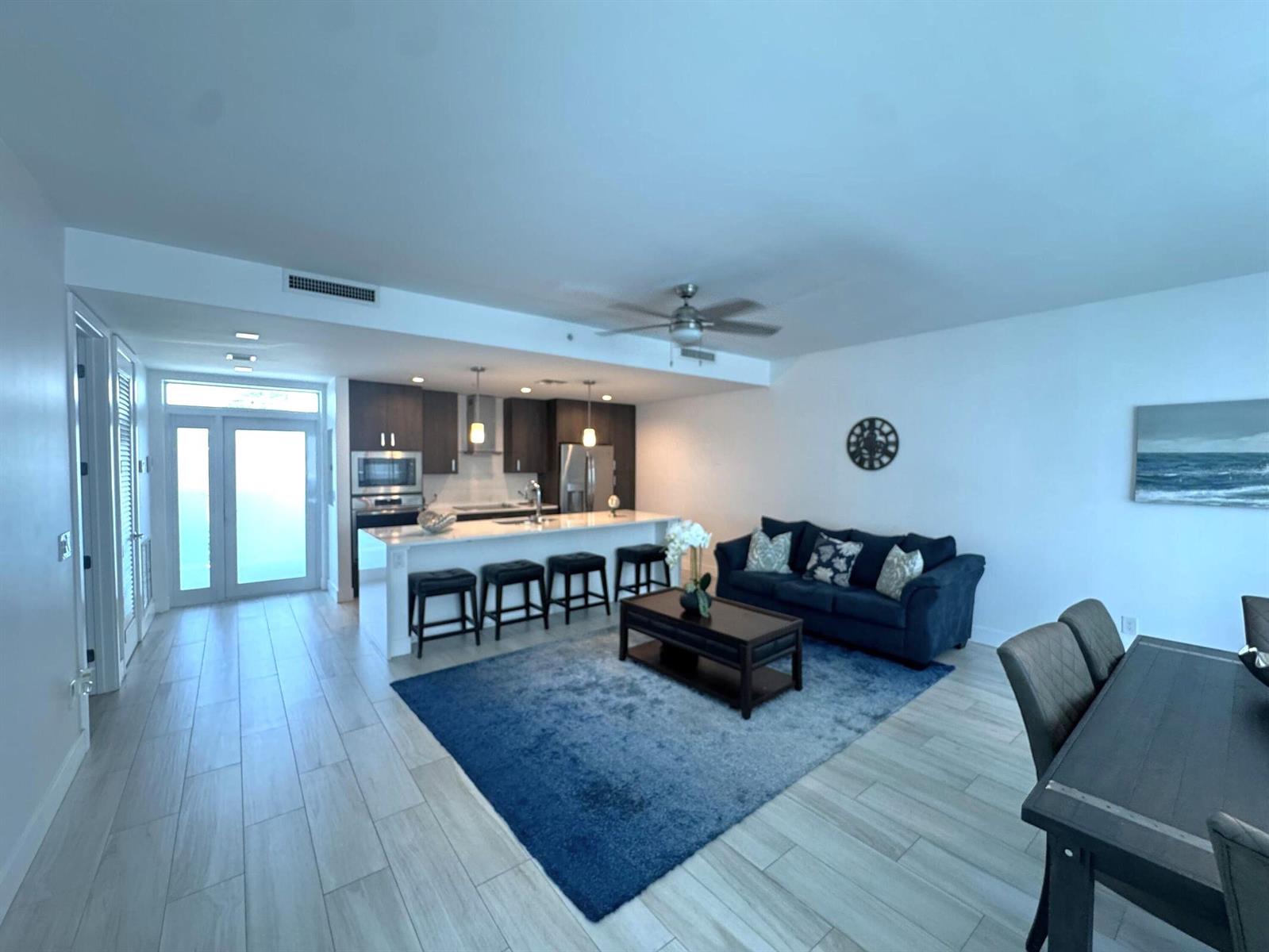 An open-concept living area features a kitchen with a breakfast bar and a blue sofa — 1 S Palmway # 204, FL 33460, FL