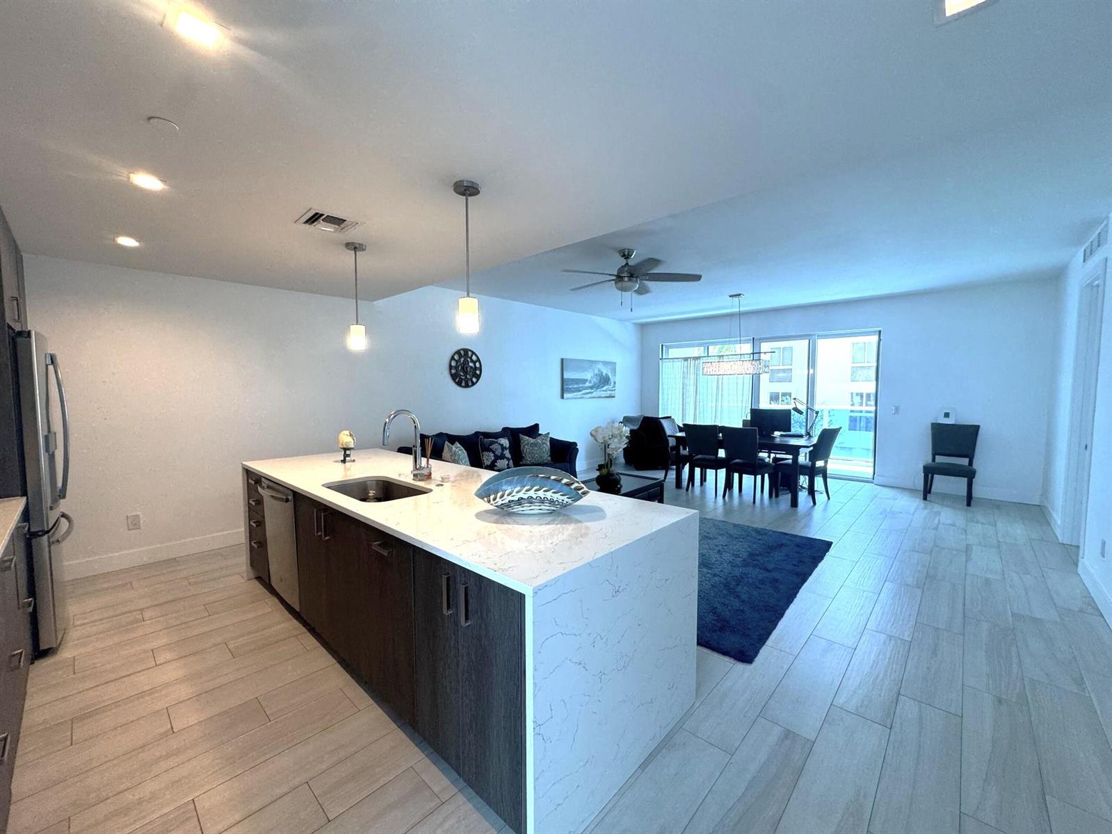 A modern kitchen island with a quartz countertop sits in an open-concept living space — 1 S Palmway # 204, FL 33460, FL